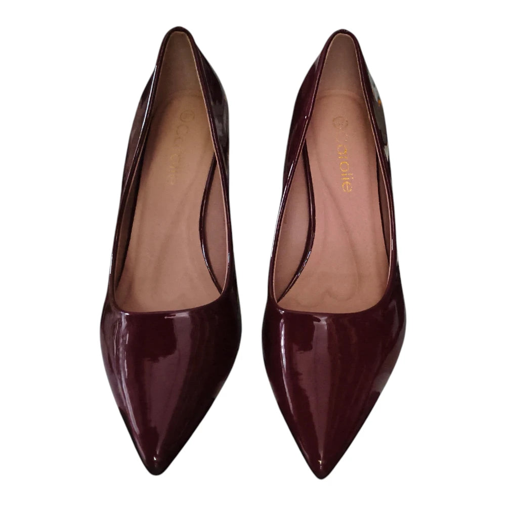 A pair of pointed-toe patent leather pumps in a deep burgundy color, shown from a top-down view on a white background.